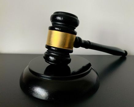 Close up of judge gavel on dark table background.