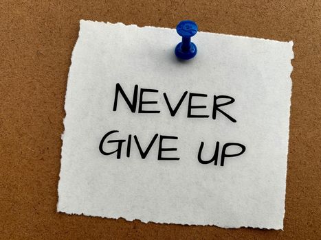 Never give up text on white notepad. Conceptual