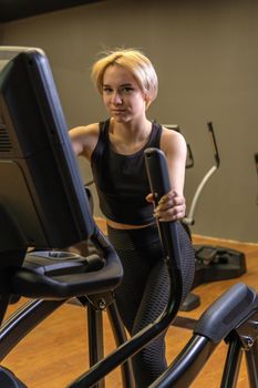 Elliptical trainer young woman person, for fitness workout in running recreation classes, room elliptical. Cardio club muscle, trainer