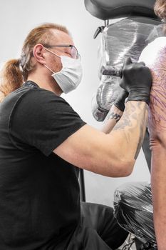 Salon tattoo. Close up of a Tattoo artist working. Tattoo artist make tattoo at the studio. High quality photography.