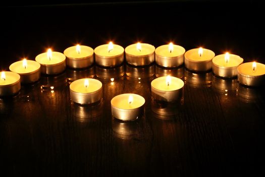 Set of flighting candles in a row against dark background