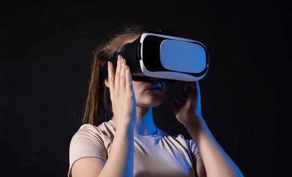 Brunette woman wearing virtual reality headset on black background