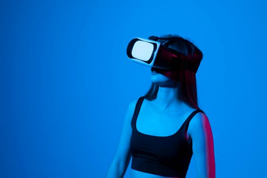 Amazed woman getting experience using glasses of virtual reality and exploring a virtual world. Girl spend shes time in metaverse while hanging out with a friends