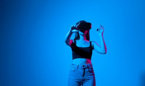 Designer, architect, engineer or developer woman stands in studio wearing VR glasses and swiping, zooming with hands in a virtual space while interacting with objects while working on project