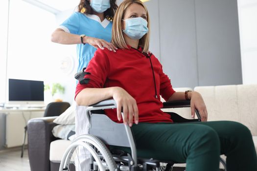 The doctor makes a neck massage to a woman in a wheelchair, close-up. Rehabilitation in the clinic after an injury