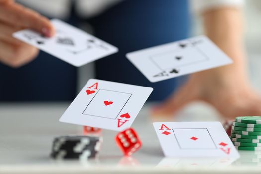 On the table are card aces and dice, casino chips, close-up, blurry. Card combination, poker layout, gambling