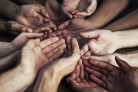 Cropped shot of a large group of unidentifiable people cupping their hands together