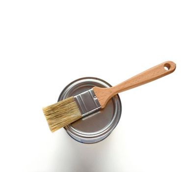White paint with paint brush on metall container over white background