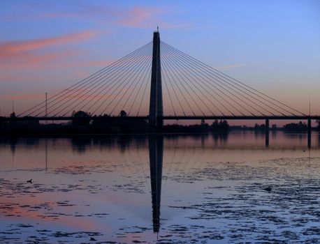 Bridge over the river in the city at sunset