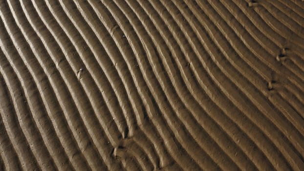 Stripes of fine sea sand on the coast. Natural background from the sand of the sea