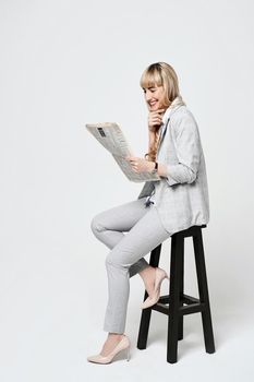 Young beautiful blonde woman in studio on light gray background.