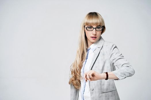 Young beautiful blonde woman in studio on light gray background.