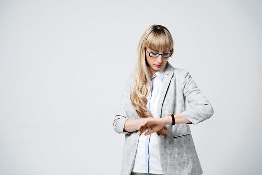 Young beautiful blonde woman in studio on light gray background.