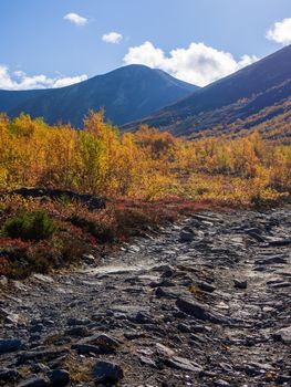 Dirt gravel road with mountains in the background. Autumn mountains of Khibiny. photo