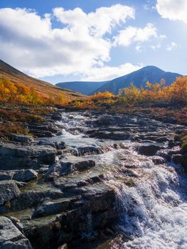 Beautiful mountain waterfall among rocks in polar summer in Khibiny Mountains. Kola Peninsula, Arctic, polar summer. photo