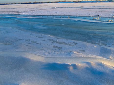 Network of cracks in thick solid layer of ice of a frozen river