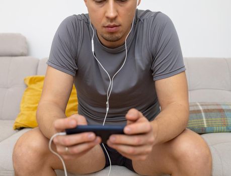 young man in headphones watching at mobile phone. High quality photo