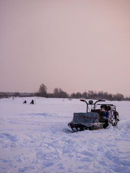 Winter fishing. Ice fishing. Fisherman, fishing on the ice. Electric snowmobile for fishing. Russia
