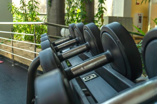 Dumbbells in blur lie on the trolley in fitness, the concept of a healthy lifestyle, during the day diagonally on the windows