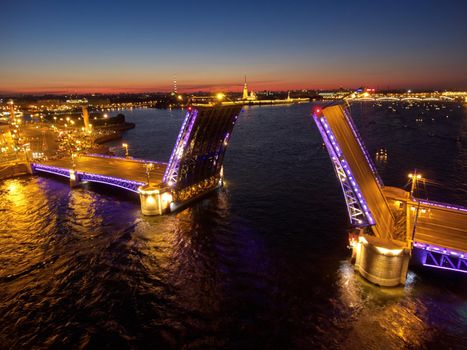 Aerial night landscape of festivities on palace embankment at bridge drawing in St. Petersburg, Russia, picturesque night illumination of landmarks, a lot of pleasure boats, a lot of people. High quality photo