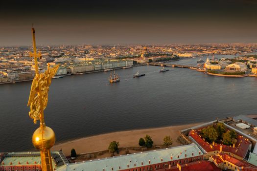 The golden angel on the cross of the Peter and Paul Fortress at sunrise, landmarks of St. Petersburg on background, Isaac cathedral, Admiralty, Rostral columns, Winter Palace. High quality photo