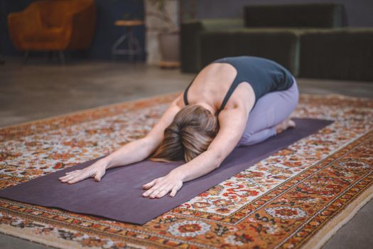 Woman Practices Yoga Asanas in the Morning for Energy for the Whole Day. Concept of health, longevity, slim figure. Close-up. High quality photo