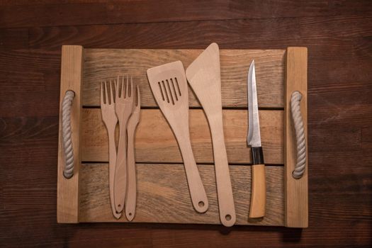 Wooden utensils set collection for your kitchen on wooden table horizontal banner layout. Top view on wooden table background.