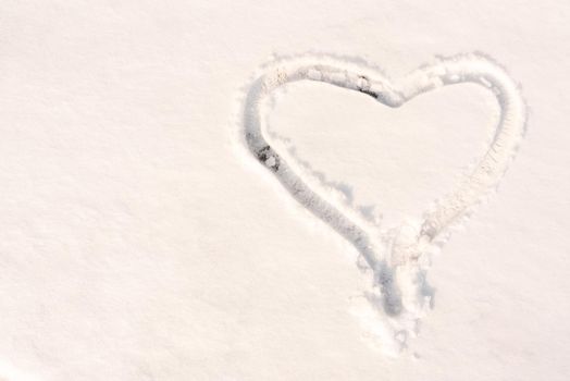 The symbol of the heart, painted on the fresh white snow with copy space.