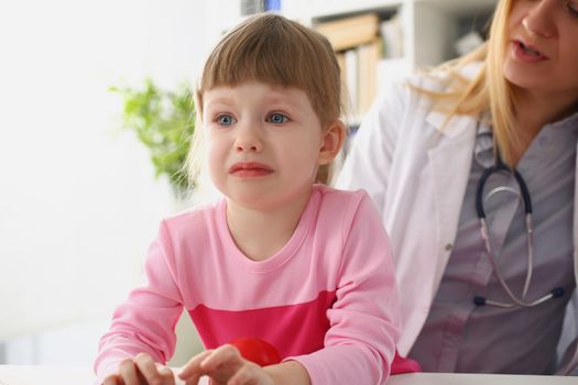 Portrait of girl cry at doctor office on consultation, upset little girl dont like hospital. Doctor calm kid down, show support. Medical, childhood concept