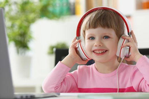 Portrait of little happy girl wearing headset, fun pastime for child on holiday. Childhood, leisure, development, preschool class, online education concept