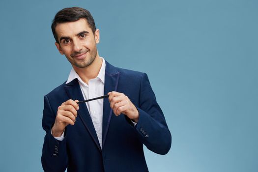 successful manholding a pen with a smile a stylish suit self-confidence isolated background. High quality photo