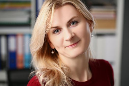 Portrait of beautiful young woman with blonde hairstyle posing on camera in office. Company worker, qualified secretary. Career, modeling, beauty concept