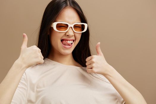 portrait woman in a beige T-shirt with glasses posing clothing fashion Green background. High quality photo