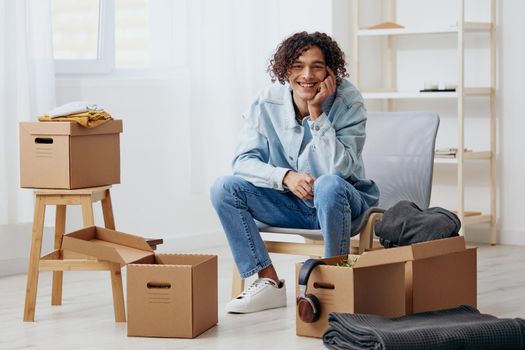 handsome guy cardboard boxes in the room unpacking interior. High quality photo