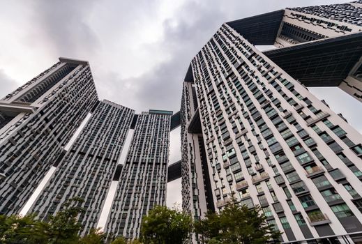 Bottom view of real estate housing in down town of Singapore, skyscraper at cloud weather. High quality photo