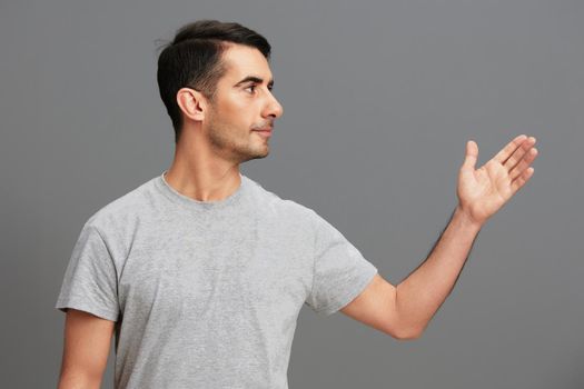 portrait man casual wear gray t-shirt fun hand gesture cropped view. High quality photo