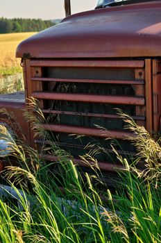 Close up of Front Grill of Abandoned Vintage and Rusty Truck in a Field on a Sunny Day. High quality photo