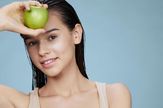 brunette green apple near face health close-up Lifestyle. High quality photo