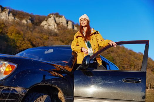 woman tourist near the car admiring the landscape mountains nature relaxation. High quality photo