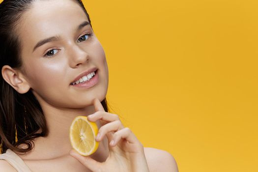 woman half a lemon vitamins health cosmetology yellow background. High quality photo