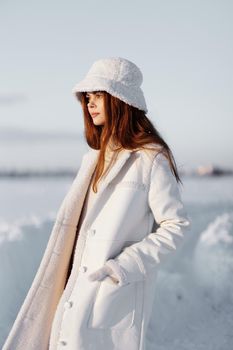pretty woman in a white coat in a hat winter landscape walk nature. High quality photo