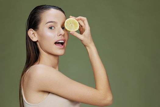 young woman lemon vitamins health cosmetology green background. High quality photo