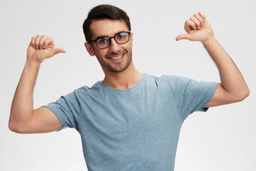 Cheerful man in blue t-shirt glasses for vision light background. High quality photo