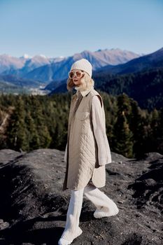 tourist in autumn clothes stands on a rock blue sky landscape. High quality photo