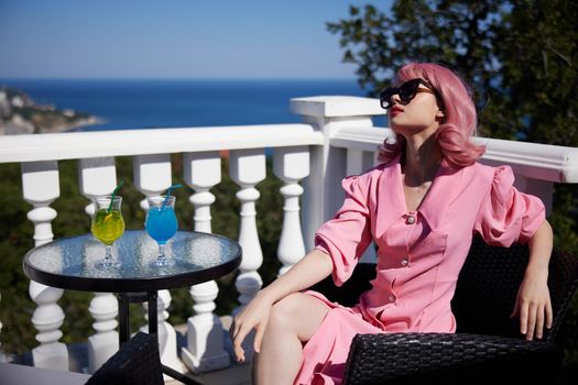attractive woman in sunglasses outdoors on the terrace cocktail relaxing unaltered. High quality photo
