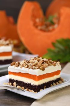 Pumpkin pie - light, creamy dessert with cheese cream and pumpkin layers topped with chopped nuts