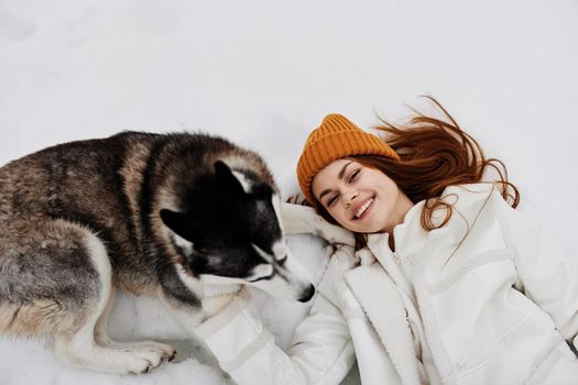 portrait of a woman winter clothes walking the dog in the snow Lifestyle. High quality photo