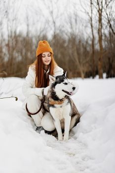 cheerful woman in the snow playing with a dog outdoors friendship winter holidays. High quality photo