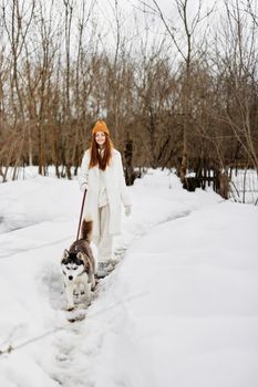 woman in the snow playing with a dog outdoors friendship winter holidays. High quality photo