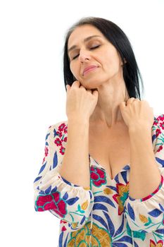 Studio photo of middle aged woman starting getting grey-haired wearing dress with flowers on white background, middle age sexy lady, cosmetology concept.